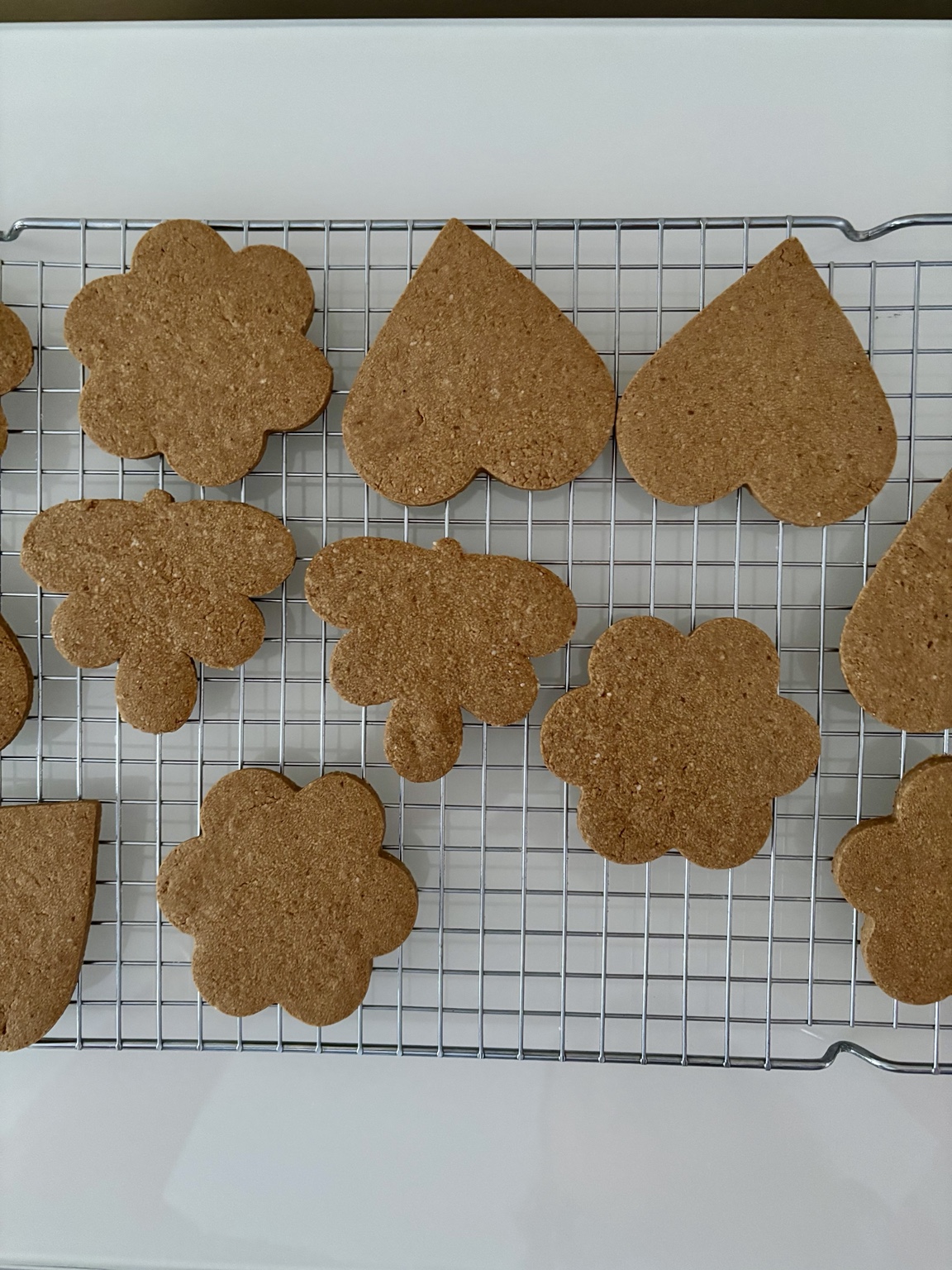 Sablés sans gluten en forme de cœurs, fleurs et papillons sur une grille